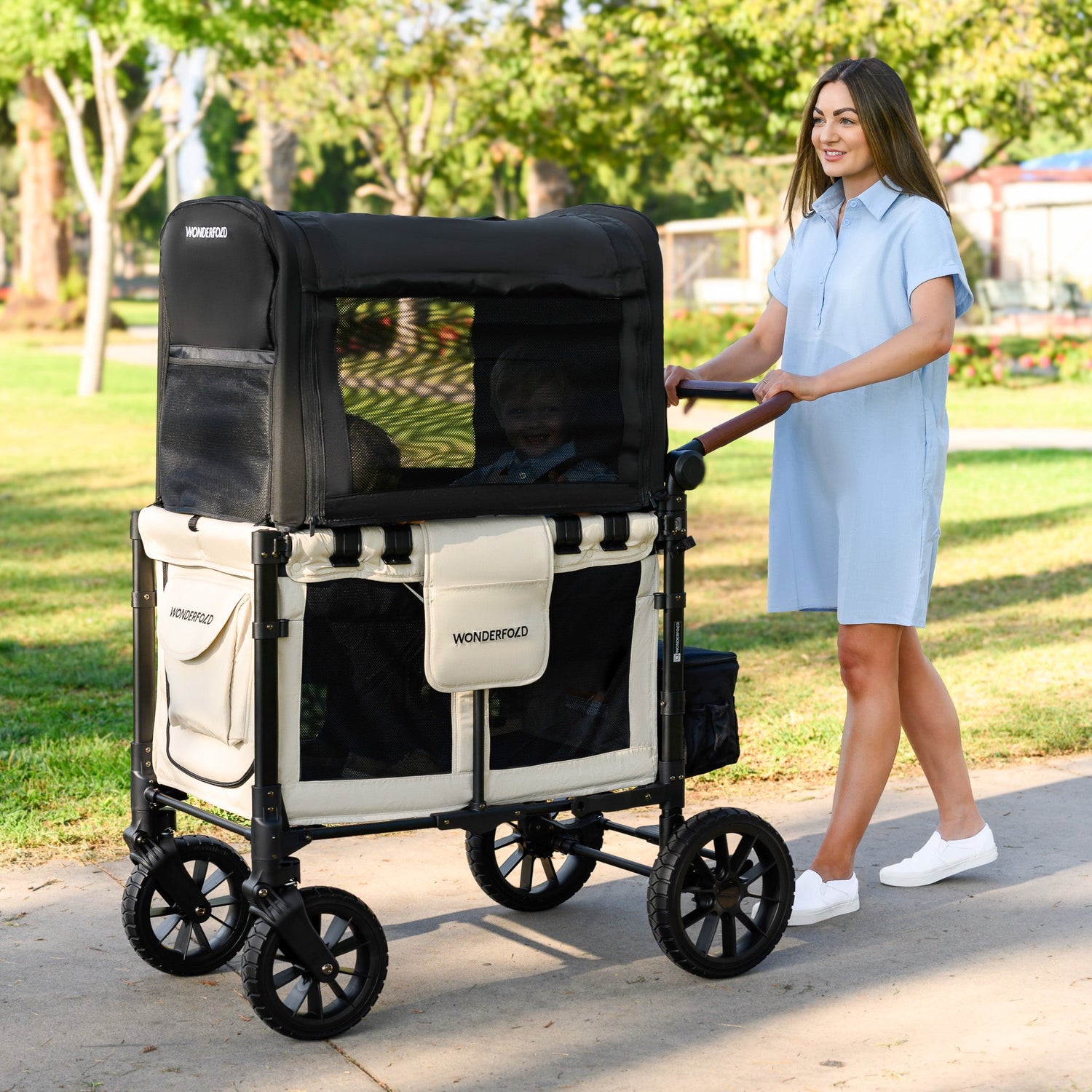 mom pushing toddler stroller wagon with full coverage canopy and mesh windows